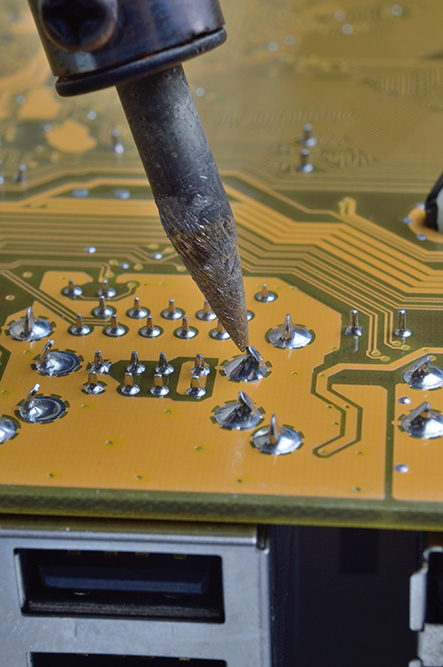 Soldering of electronic circuit board with electronic components.  Engineers repair circuit board with soldering iron.